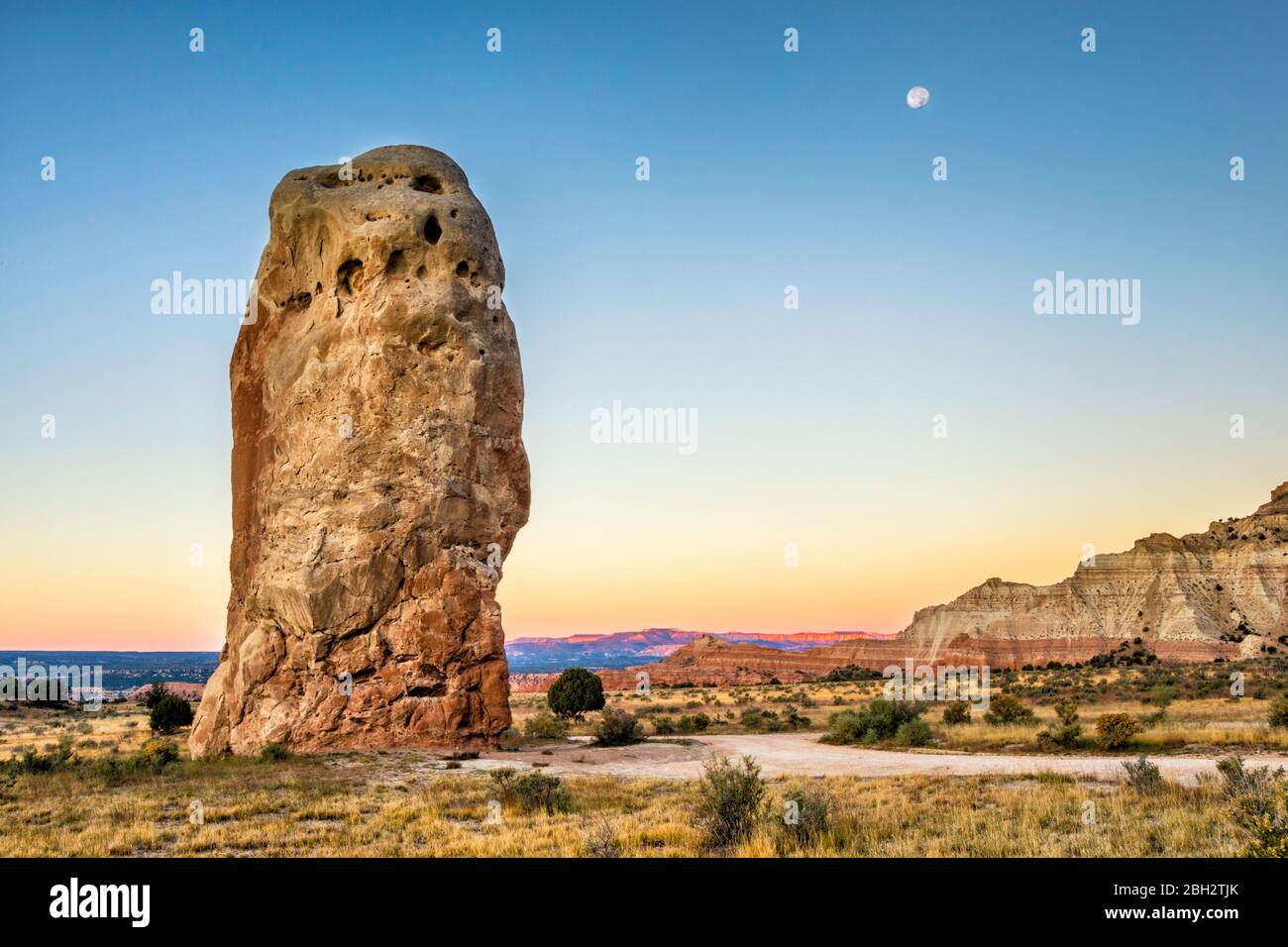 Mond über dem Chimney Rock bei Sonnenaufgang, Bryce Canyon Formation in weiter Ferne, Kodachrome Basin State Park, Utah, USA Stockfoto