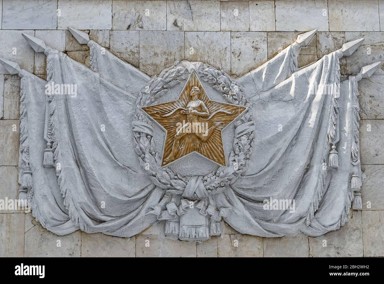 Moskau, Russland 25. Juni 2013: Bas-Relief-Athlet auf dem Hintergrund der Fahnen im Pavillon der Sportausbildung und Sport bei VDNH. Das sowjetische Abzeichen Stockfoto