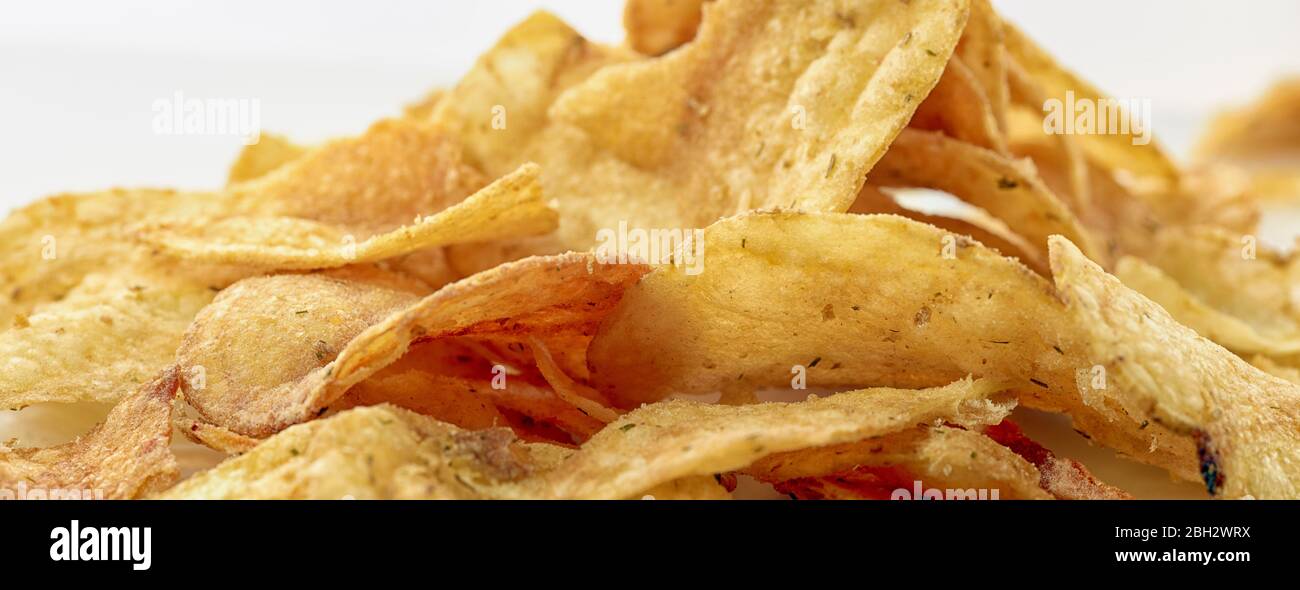 Nahaufnahme eines Lebensmittelporträts von Kartoffelchips (Kartoffelchips) vor hellem Hintergrund Stockfoto