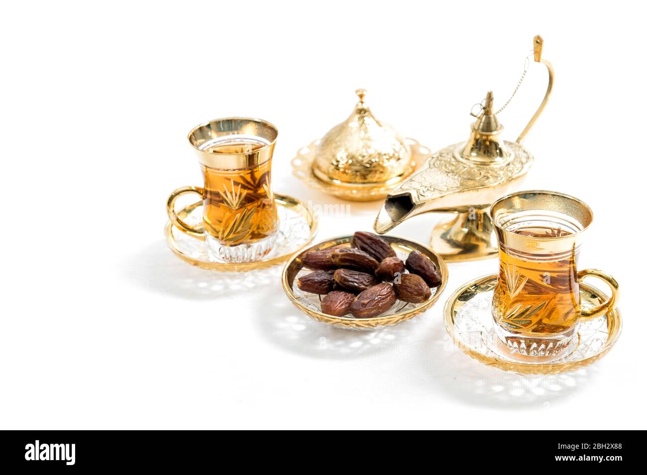 Teegläser mit Datteln auf weißem Hintergrund. Orientalische Gastfreundschaft Stockfoto