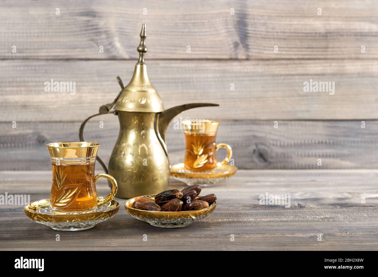 Teetafel mit goldener orientalischer Dekoration auf rustikalem Holzhintergrund Stockfoto
