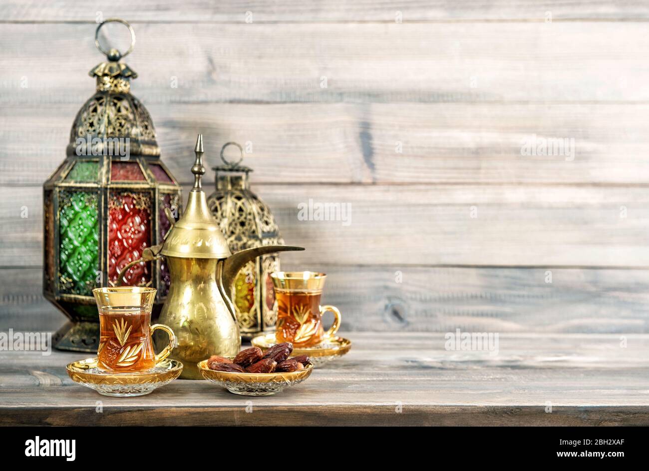 Teegläser mit Datteln und orientalischer Laterne-Dekoration auf Holzhintergrund Stockfoto