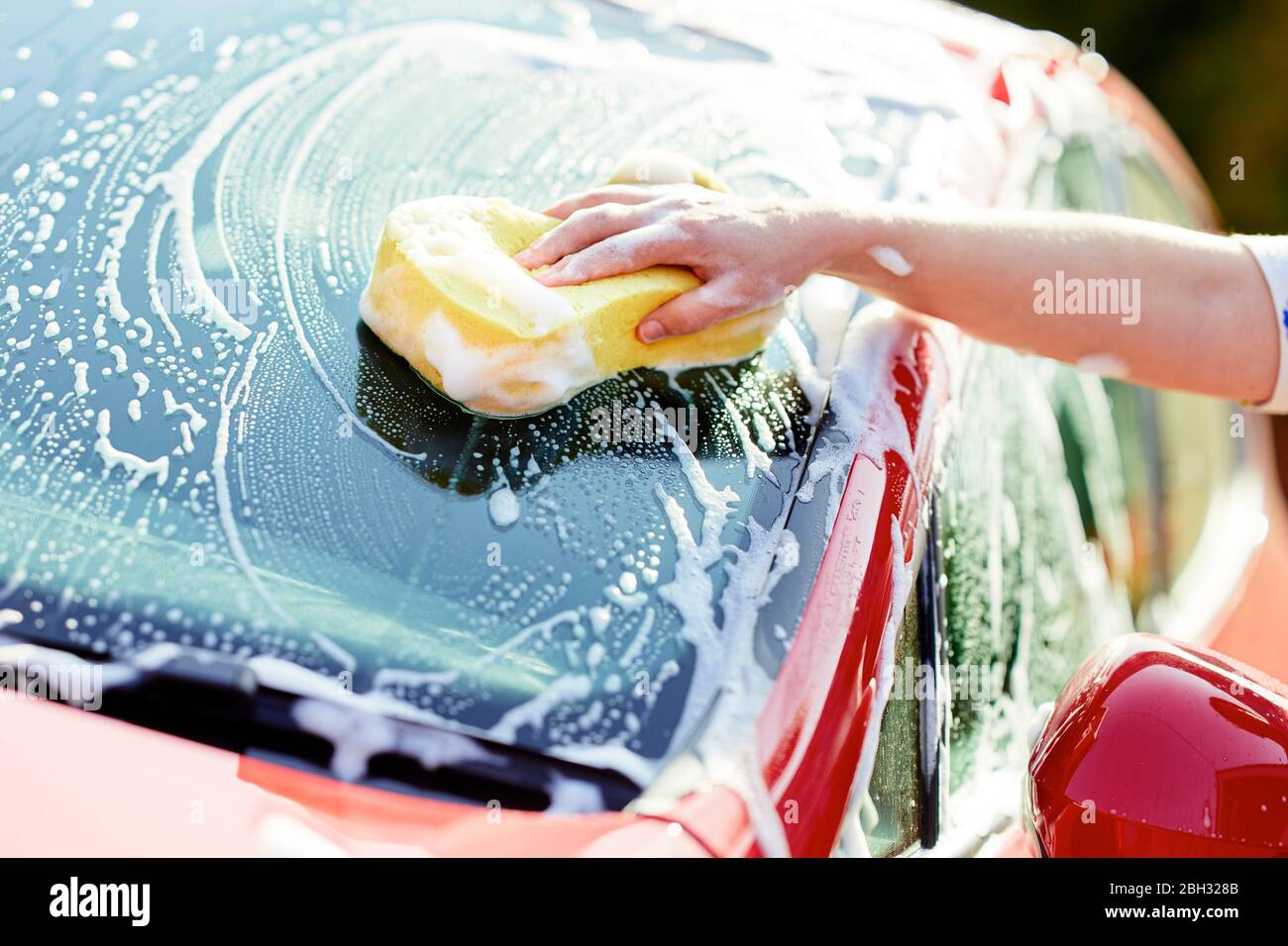 Frau, die ihr Auto waschen Stockfoto