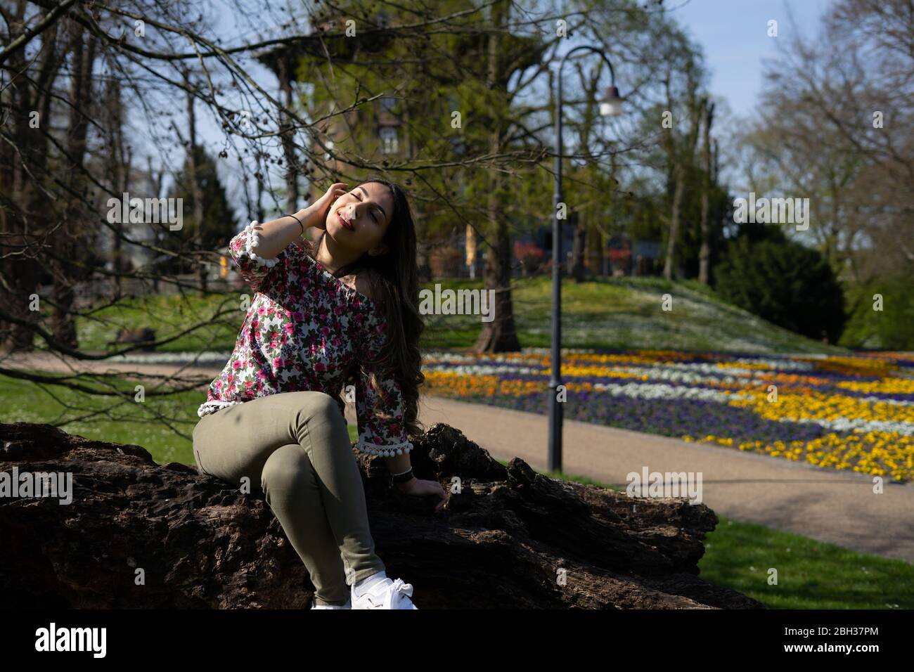 Naher Osten Mitte Alter Frau Modell posiert im Frühjahr mit einer Blumenbluse rund um einen Park in Bremen. Stockfoto