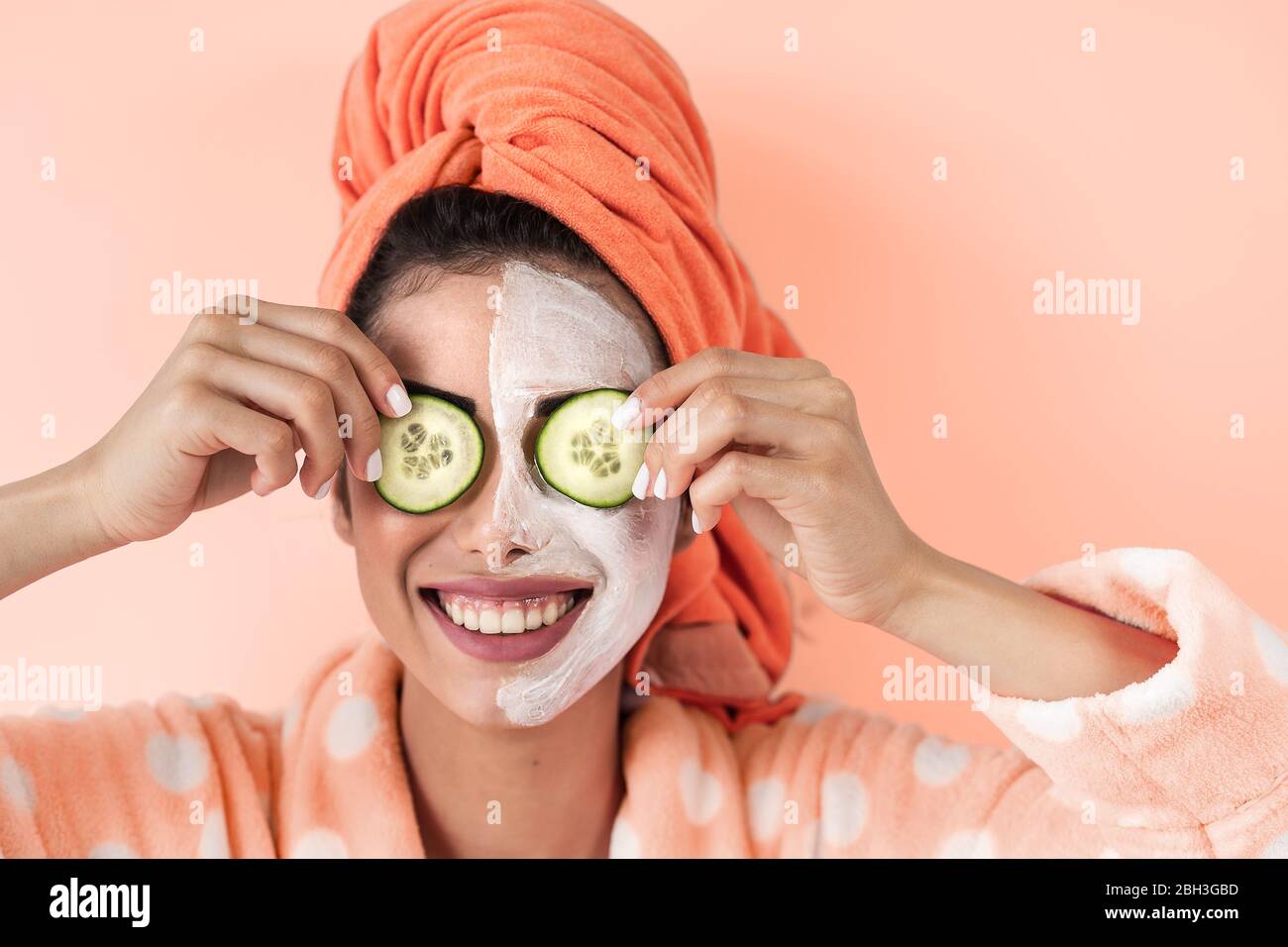 Junge Frau mit Hautpflege Spa Tag zu Hause - Happy girl Anwendung Gurke Gesichtsreinigung Maske Stockfoto