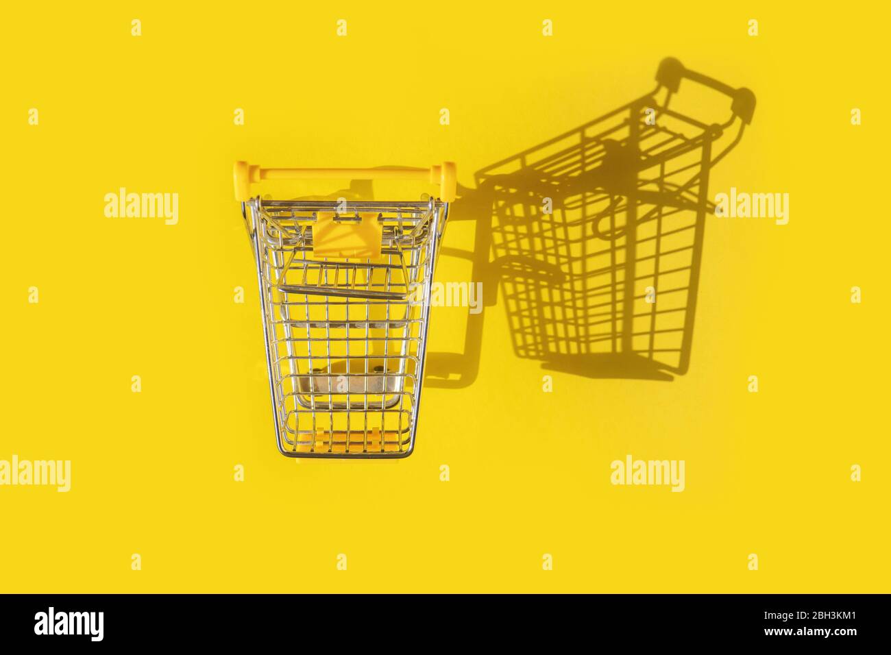 Draufsicht des leeren Warenkorbs mit Schatten auf gelbem Hintergrund. Stockfoto