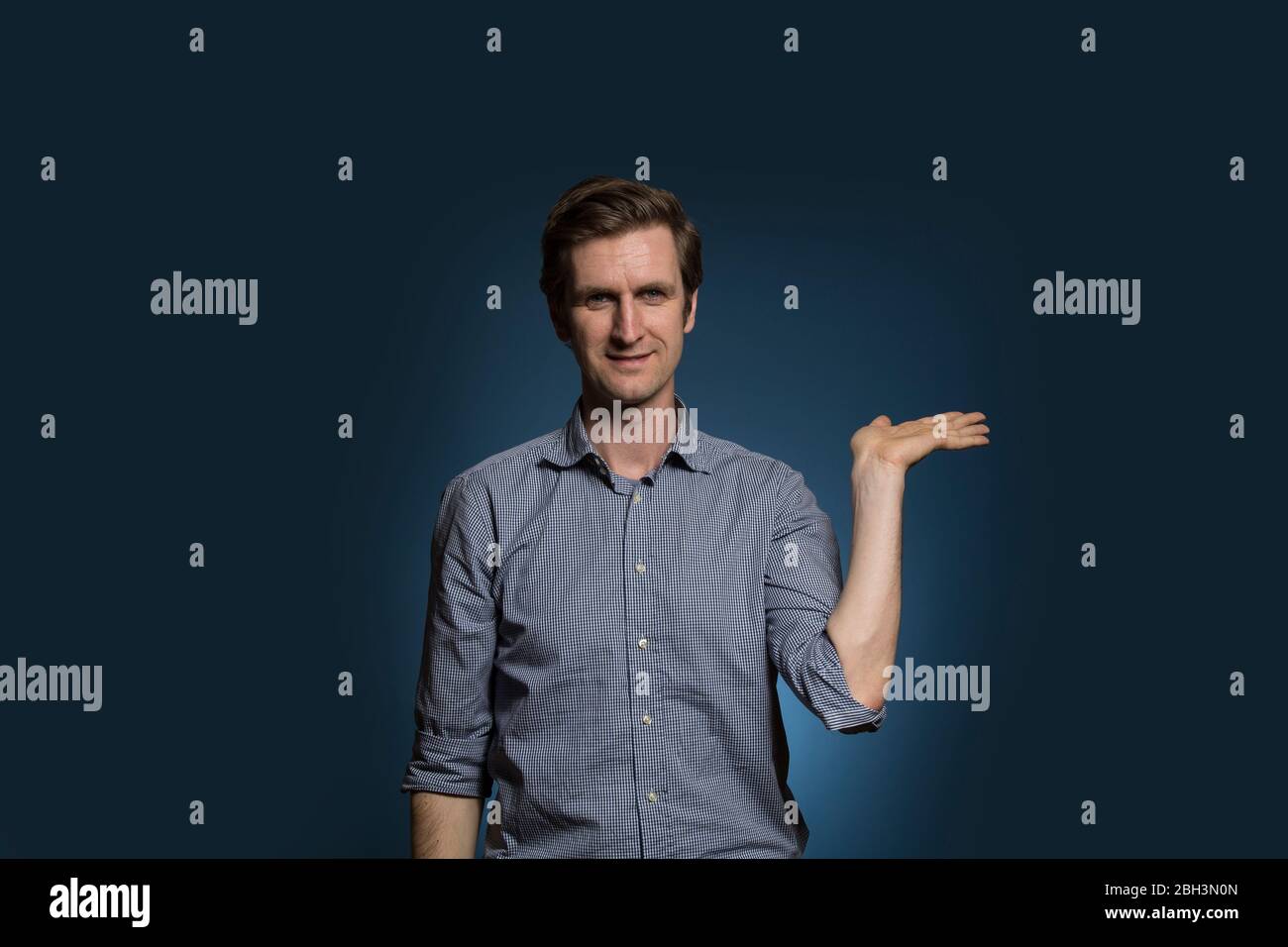 Mann hält die Hand auf und lächelt Stockfoto