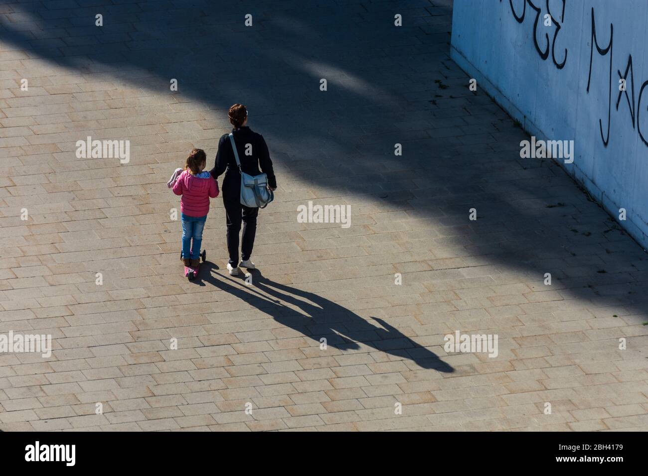 Wien, Wien: Frau, die mit Kind geht, langer Schatten, in , Wien, Österreich Stockfoto