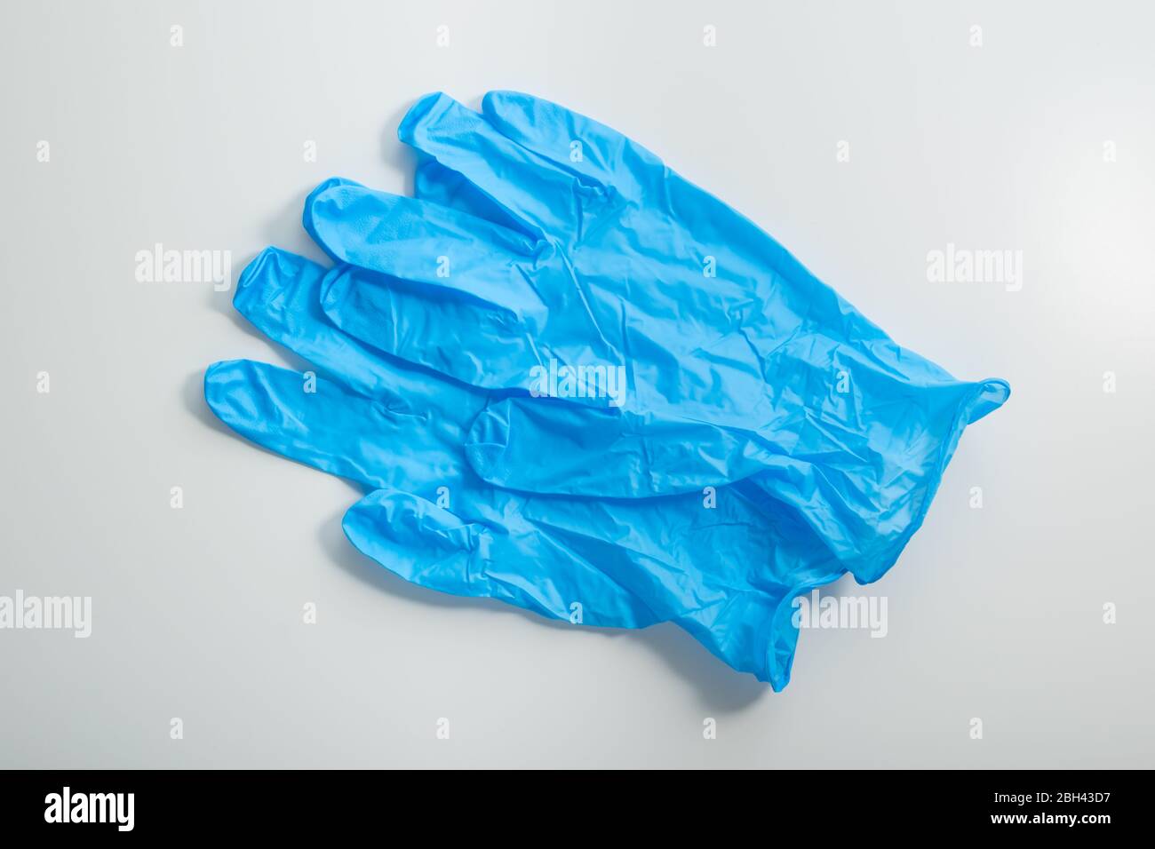 Ein Paar blaue medizinische Handschuhe auf weißem Hintergrund Draufsicht. Stockfoto