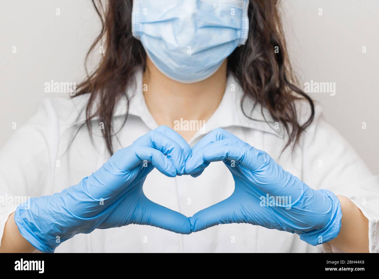 Stoppen Sie SARSCoV, Virus 2020, chinesisches Virus COVID-19. Damen Hand in blauen medizinischen Handschuhen zeigen Herz Zeichen. Konzept des Schutzes gegen HIV. Arzt in Stockfoto