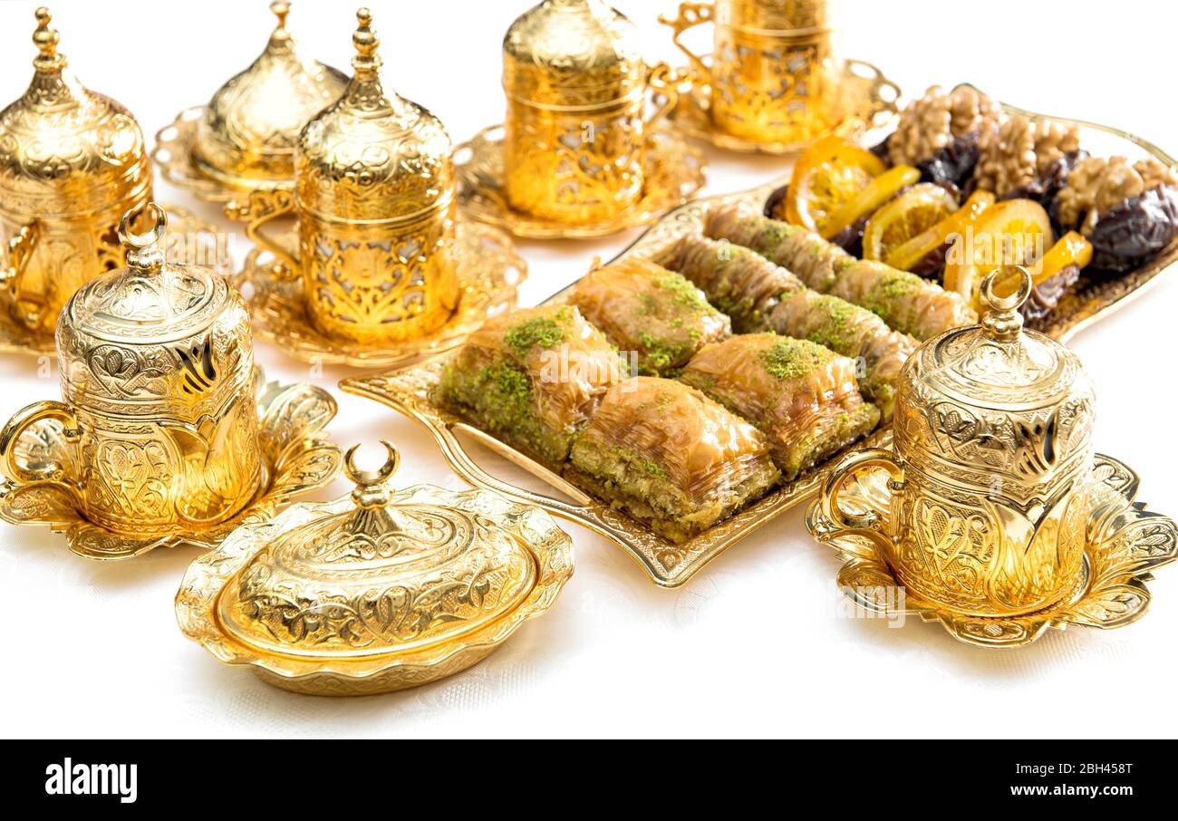 Arabische Gaumenfreuden, Teetassen und goldene Dekorationen. Orientalische Gastfreundschaft Stockfoto