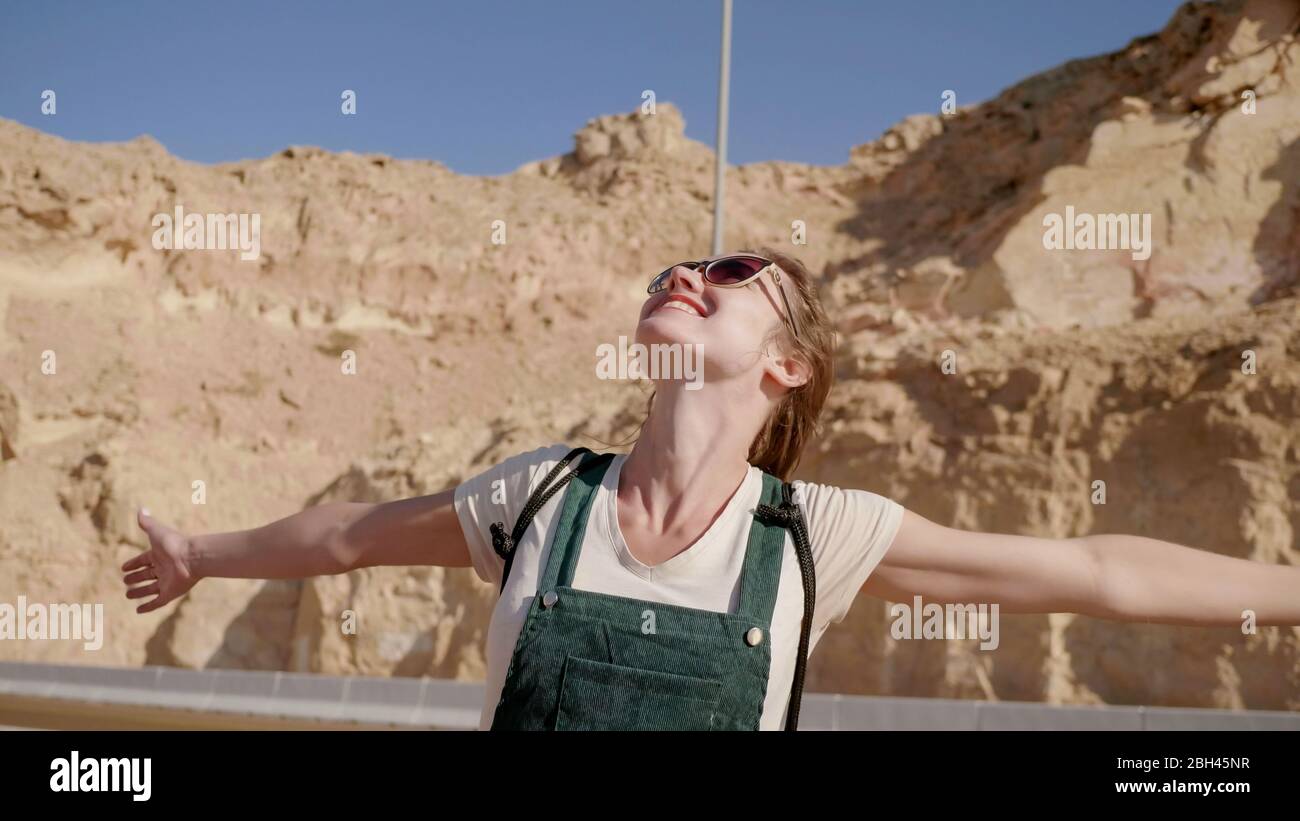 Fröhliches Mädchen posiert vor der Kulisse der Berge der Stadt Al Ain. Vereinigte Arabische Emirate. Stockfoto