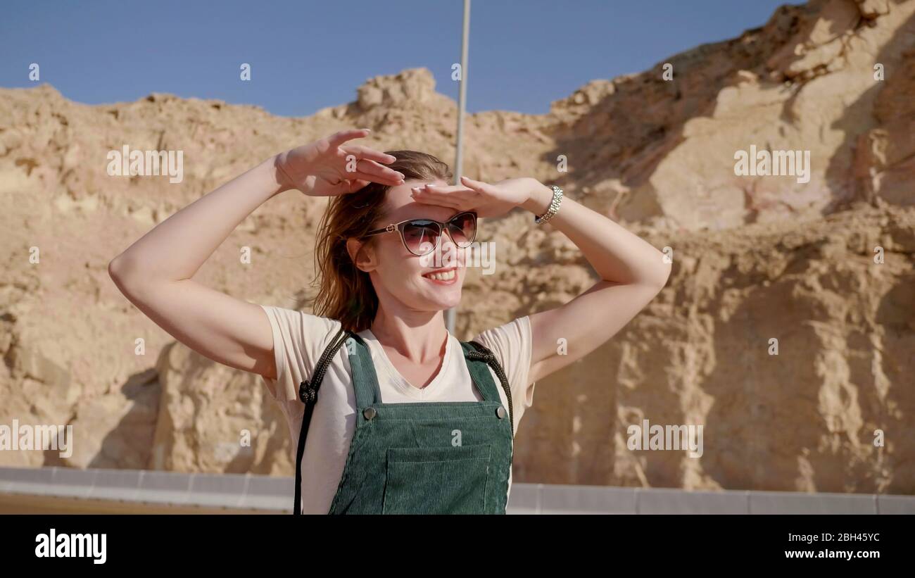 Fröhliches Mädchen posiert vor der Kulisse der Berge der Stadt Al Ain. Vereinigte Arabische Emirate. Stockfoto