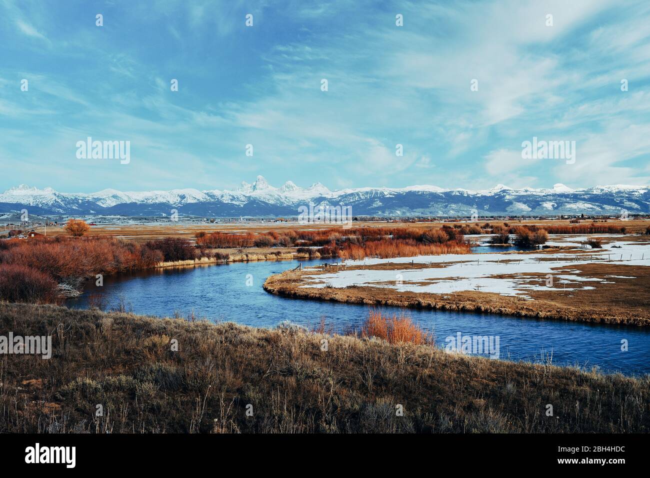 Malerischer Blick auf die schneebedeckte Teton-Bergkette mit einem gewundenen Fluss im Vordergrund. Tetonia, Idaho. Teton landschaftlich schöne Nebenstraße Stockfoto