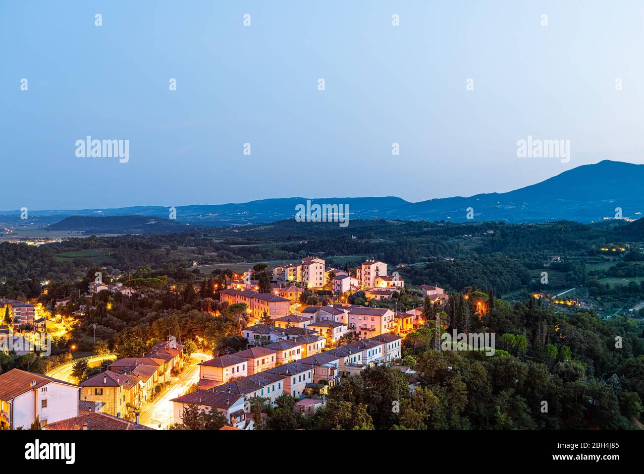 Chiusi Dorf bei Nacht in der Toskana, Italien mit beleuchteten Lichtern auf Straßen und Dachhäusern auf Bergland und sanften Hügeln Stockfoto