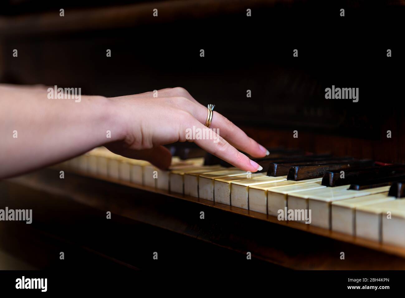 Altes Forte-Klavier mit weiblicher Hand und Diamant-Ring-Finger-Pianistin spielen Nahaufnahme für Konzert mit schwarzem Hintergrund Stockfoto