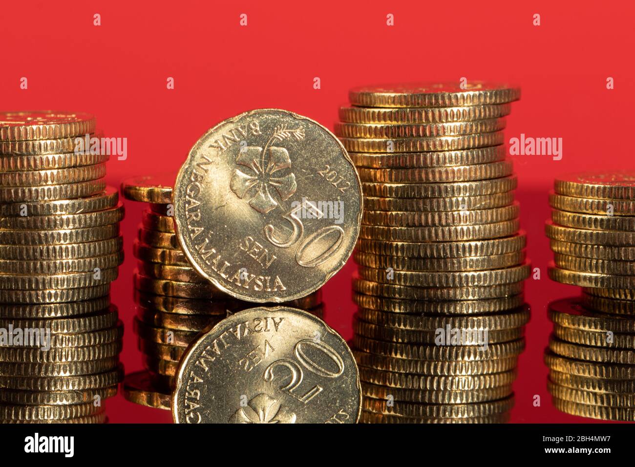 Malaysische Ringgit-Münzen in Nahaufnahme mit rotem Hintergrund und Spiegelung Stockfoto