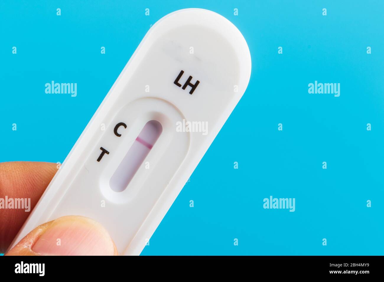 Mann Hand mit der Hand schwanger Test Kit auf blauem Hintergrund. Stockfoto