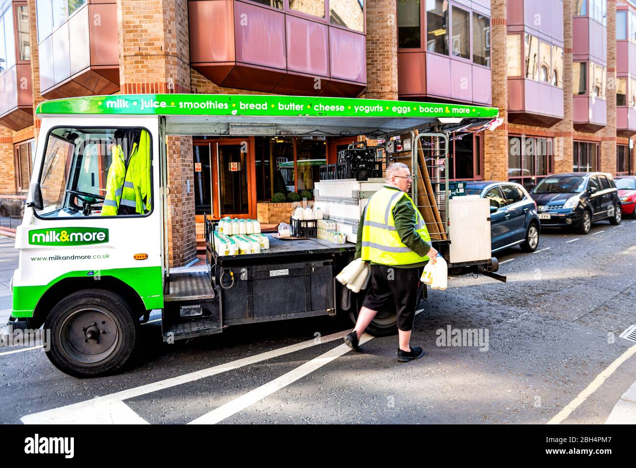 London, Großbritannien - 22. Juni 2018: Nachbarschaft von Westminster mit Mann, der Milch mit Krügen mit grünem LKW und Schild bringt Stockfoto