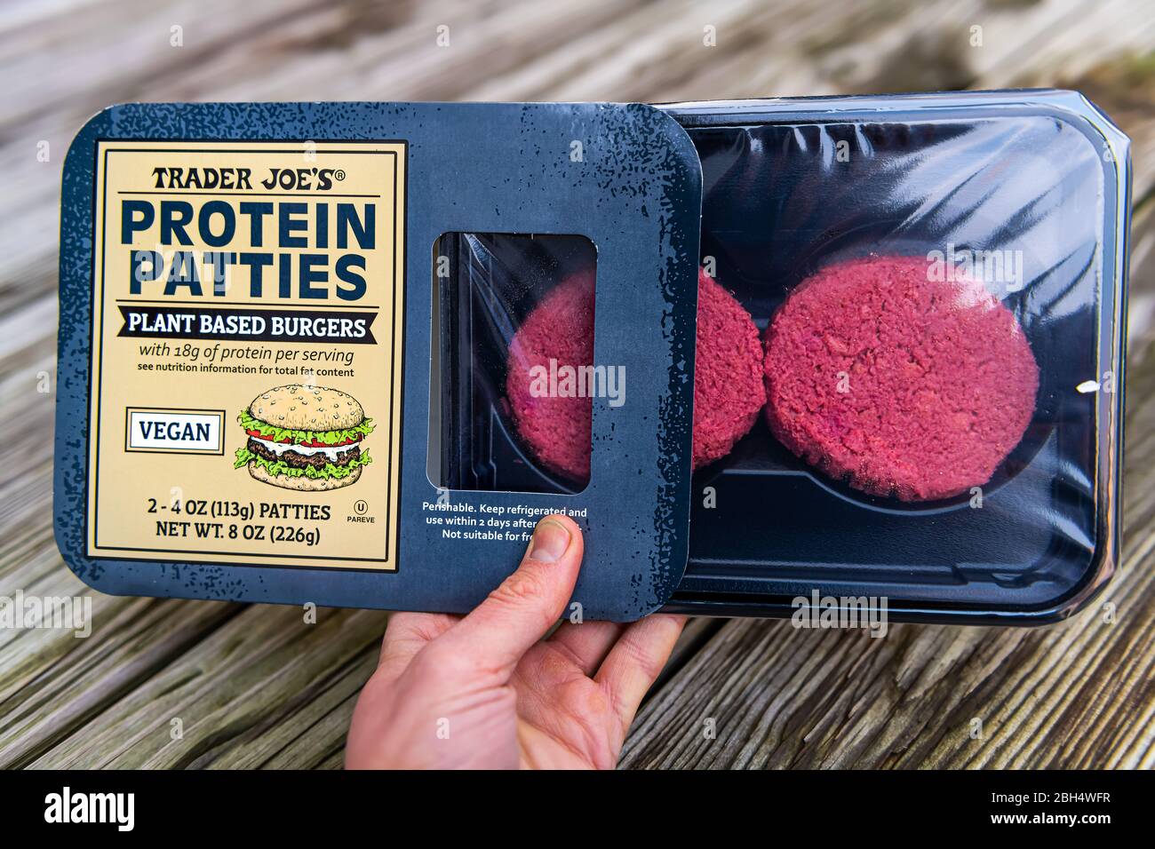 Reston, USA - 25. Januar 2020: Handperson, die Trader Joes Private Label Protein Patties als Zeichen für pflanzenbasierte vegane Burger in Nahaufnahme hält Stockfoto