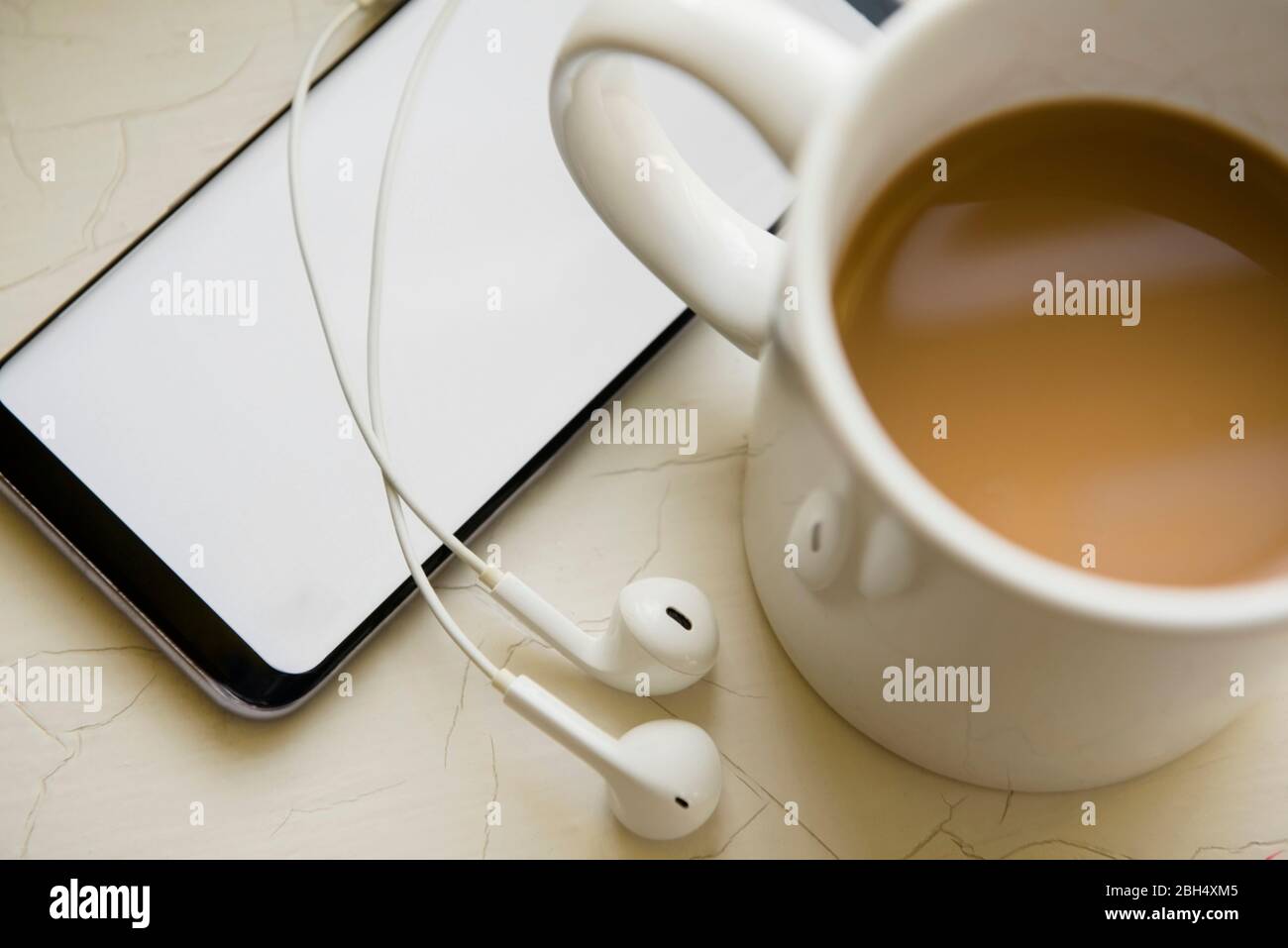 Kopfhörer, Smartphone und eine Tasse Kaffee Stockfoto