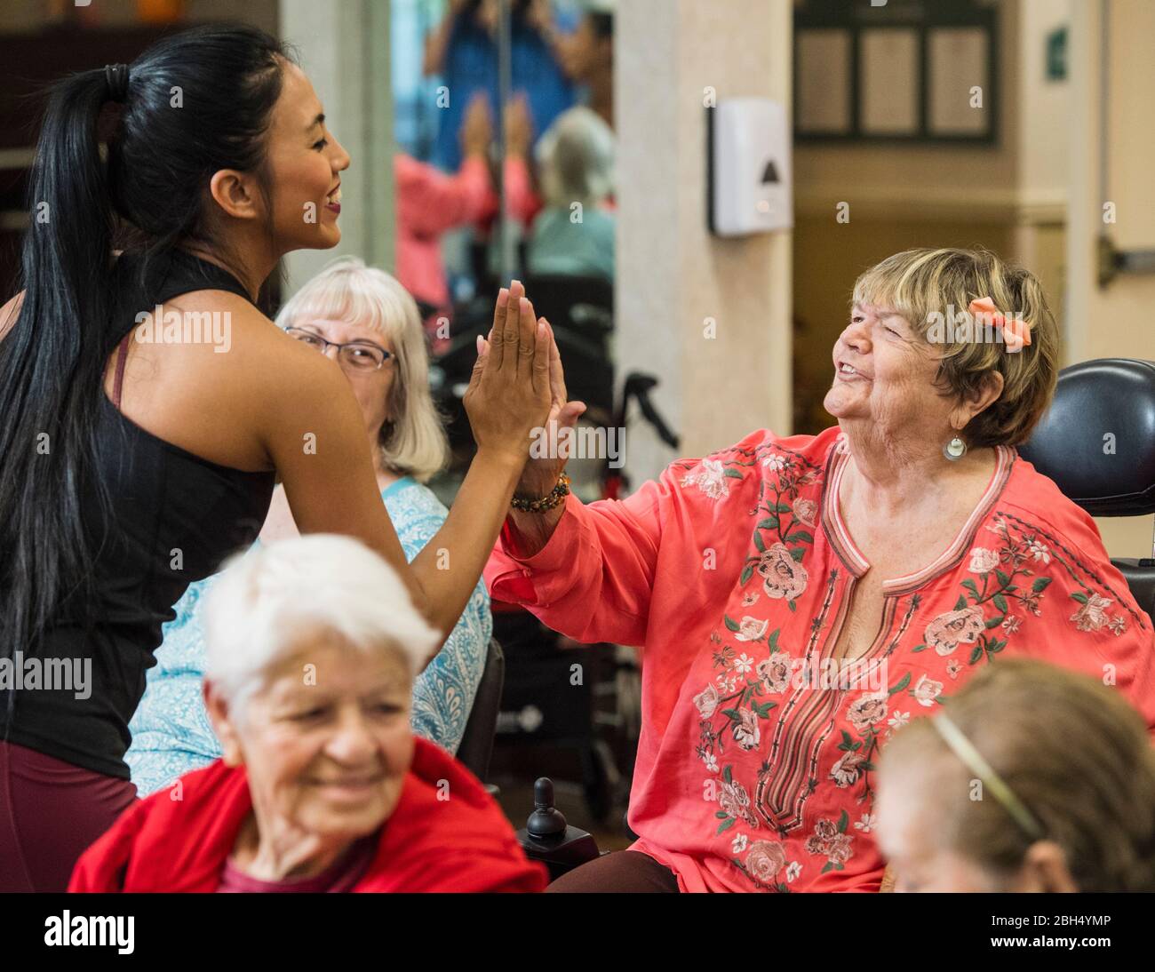 Lächelnde Fitness-Trainer High-Fünffälige lächelnde ältere Frau Stockfoto