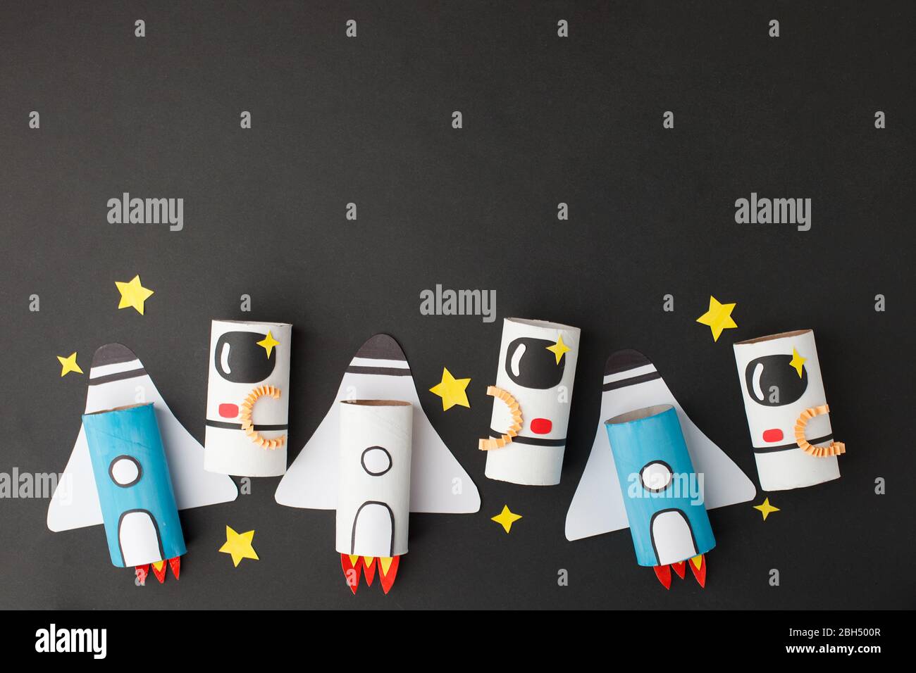 Schule Kindergarten Handwerk, Papier Raumschiff, Shuttle, Astronaut auf schwarzem Hintergrund mit Kopierraum für Text. Party, Start up Launch Konzept, diy, cre Stockfoto