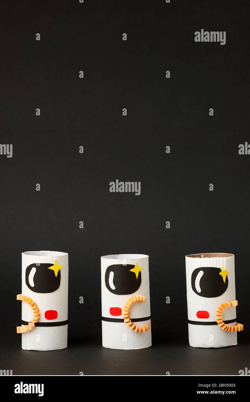 Spielzeug Astronaut auf schwarzem Hintergrund mit Kopie Raum für Text. Konzept der Geschäftseinführung, Start-up, Handwerk, diy, kreative Idee aus Toilettenröhre, rec Stockfoto