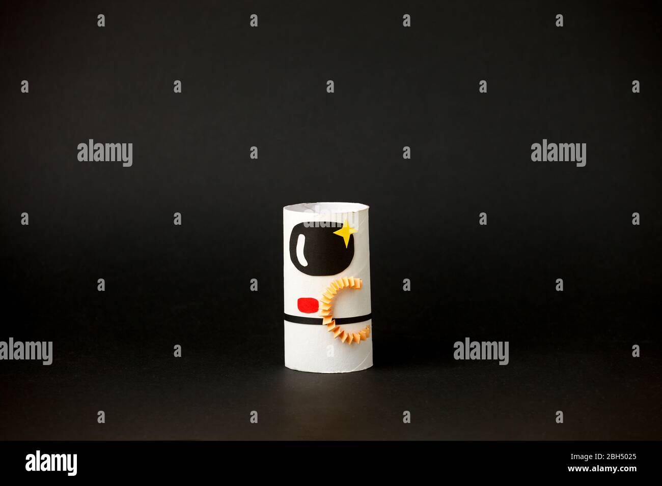 Spielzeug Astronaut auf schwarzem Hintergrund mit Kopie Raum für Text. Konzept der Geschäftseinführung, Start-up, Handwerk, diy, kreative Idee aus Toilettenröhre, rec Stockfoto