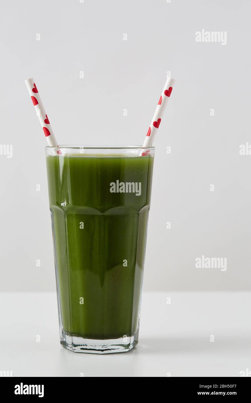 Grüner Saft in Tasse mit Trinkhalmen Stockfoto