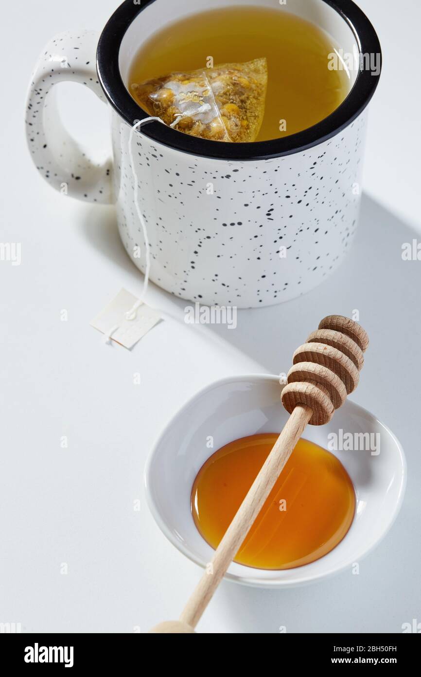 Tasse Tee, Honig Dipper und Schüssel mit Honig Stockfoto