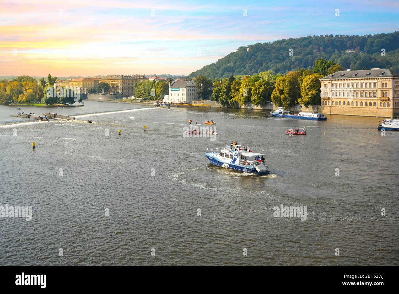 Ein geschäftiges Tag, an dem Boote und Flöße die Moldau kreuzen und auf einer Rettungsmission in der Nähe der Karlsbrücke in Prag, Tschechien, erscheinen. Stockfoto