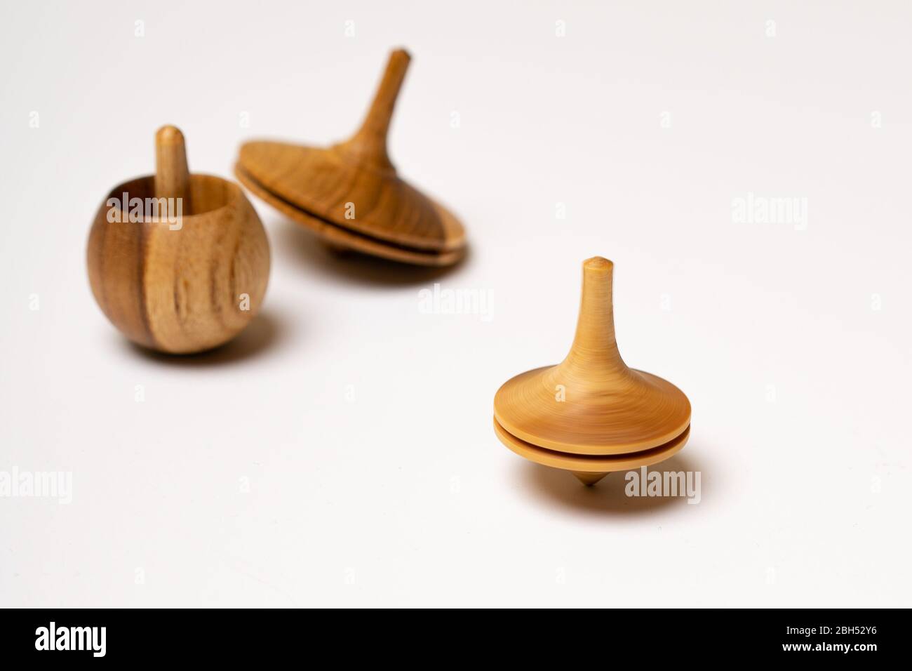 Drei Driedles hölzerne Spinning Top traditionelle Chanukkah Spielzeug jüdischen Urlaub weißen Hintergrund Raum für Text Marmor Stockfoto