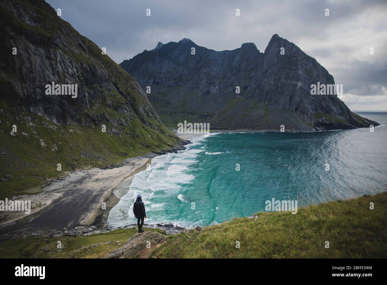 Mann auf Felsen am Kvalvika Strand in den Lofoten Inseln, Norwegen Stockfoto