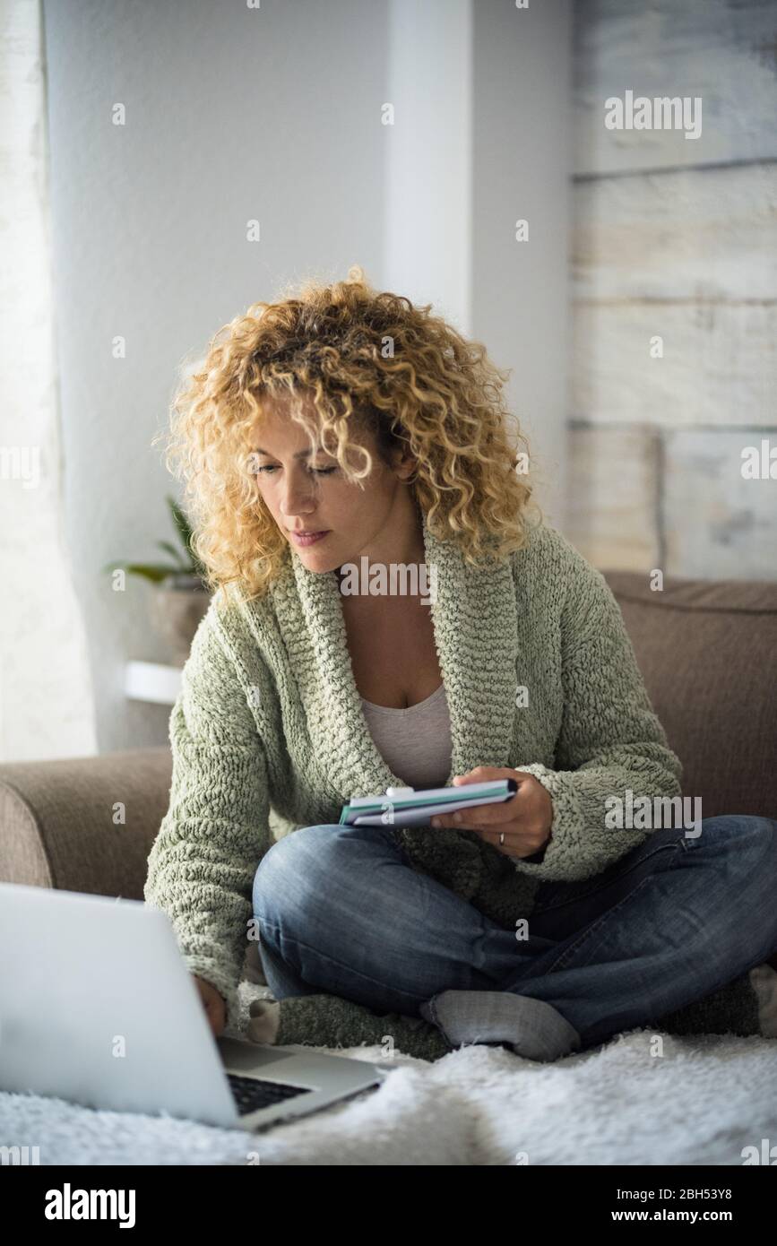 Frau, die mit einem Laptop auf dem Sofa arbeitet Stockfoto