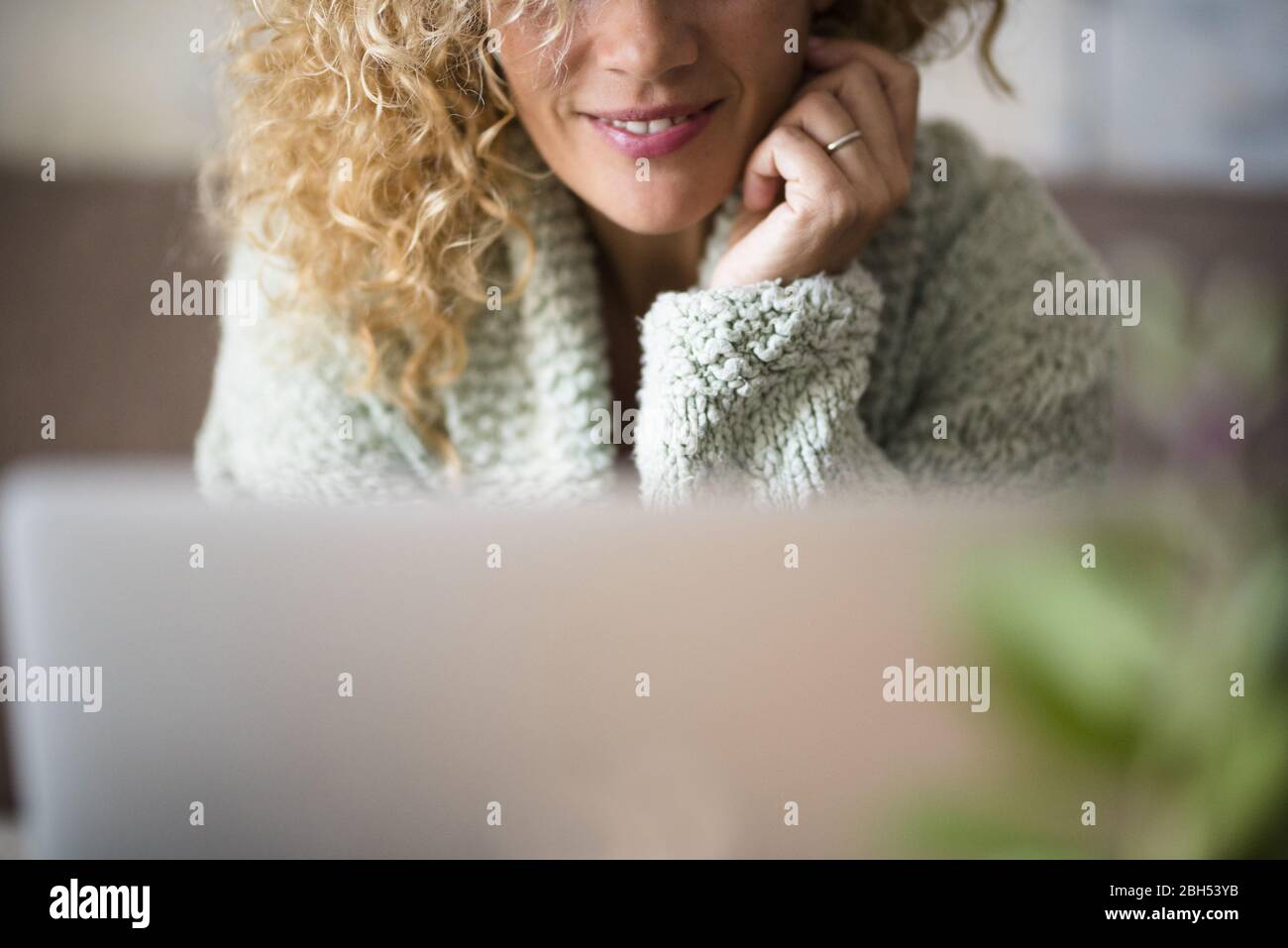 Frau lächelt hinter dem Laptop Stockfoto