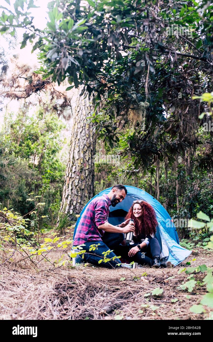 Lächelndes Paar hält die Flasche am Zelt Stockfoto