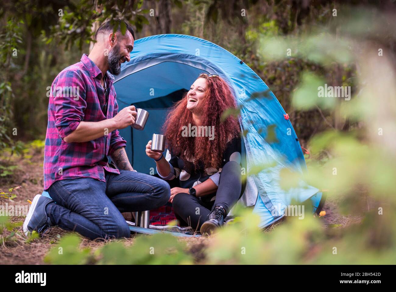 Lächelndes Paar, das im Zelt trinkt Stockfoto