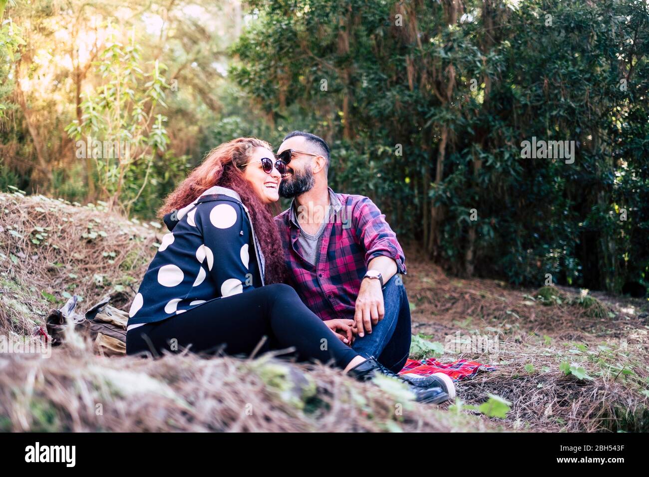 Lächelndes Paar sitzt auf Gras Stockfoto