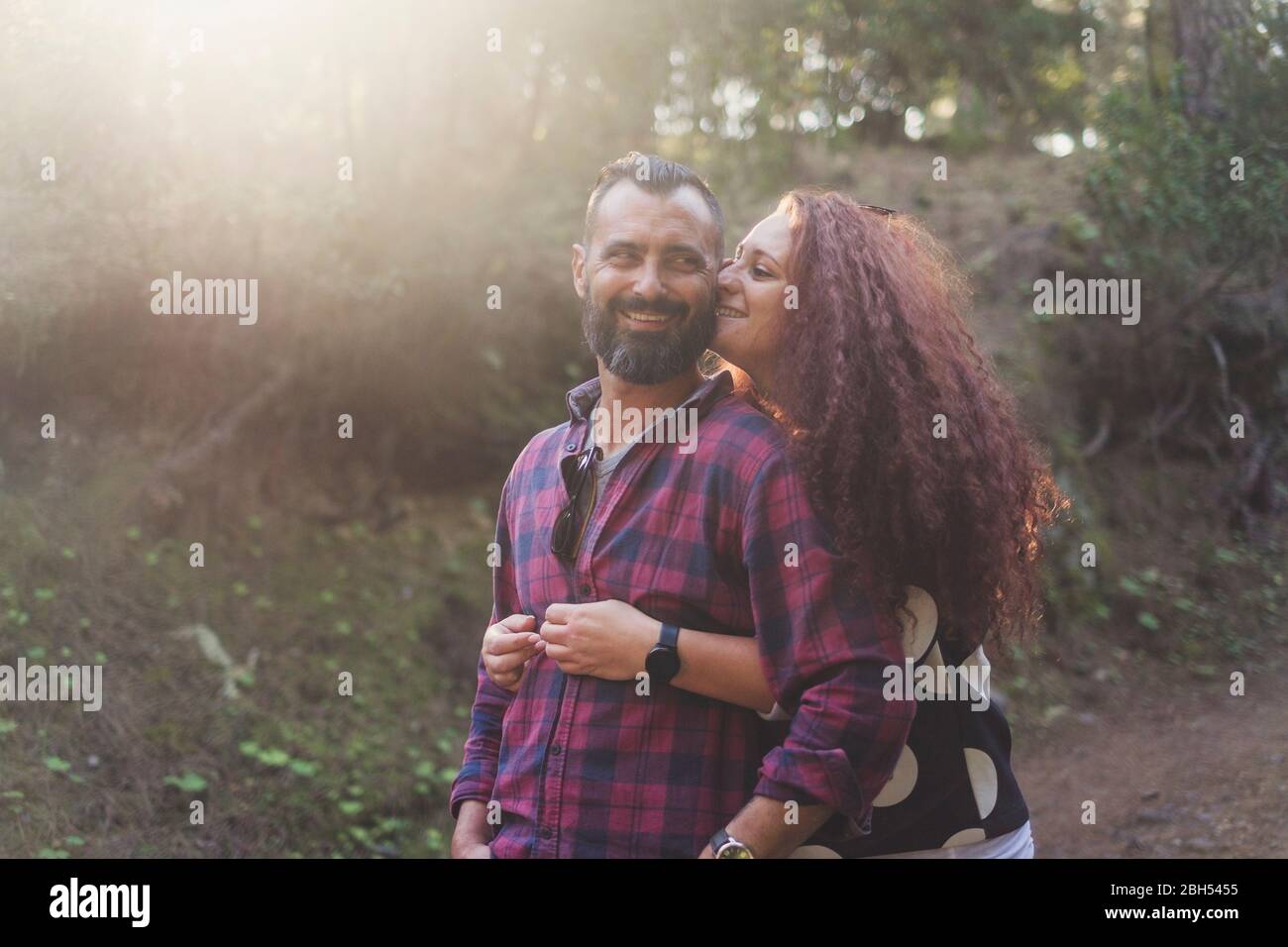 Lächelndes Paar umarmt im Wald Stockfoto