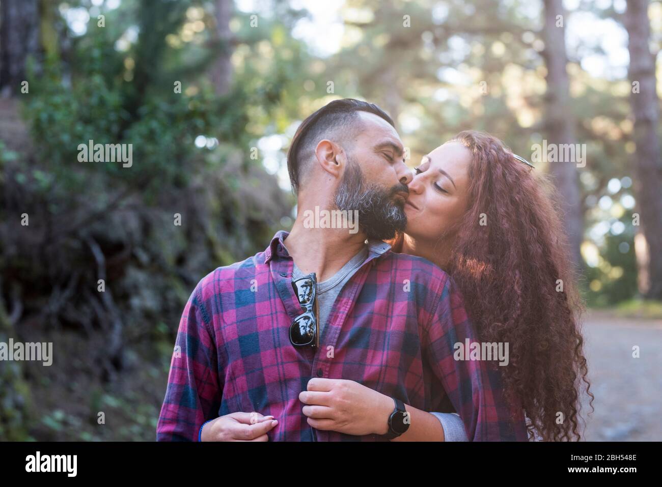 Paar küssen von Bäumen Stockfoto