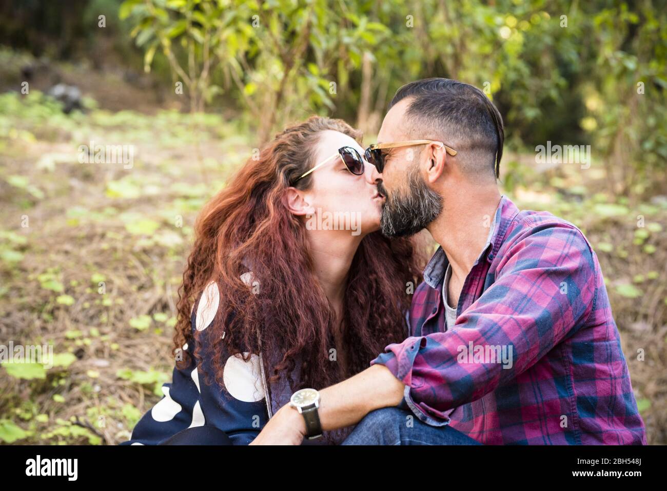 Paar küssen von Bäumen Stockfoto