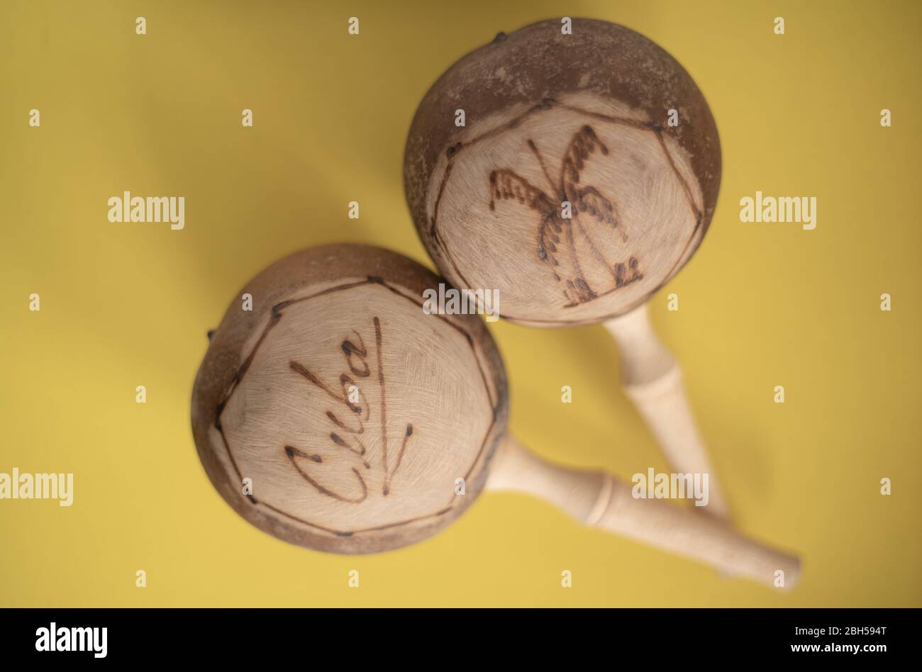Kubanische Maracas. Traditionelle Musikinstrument isoliert Nahaufnahme aus Holz natürlichen Materialien auf gelbem Hintergrund Stockfoto