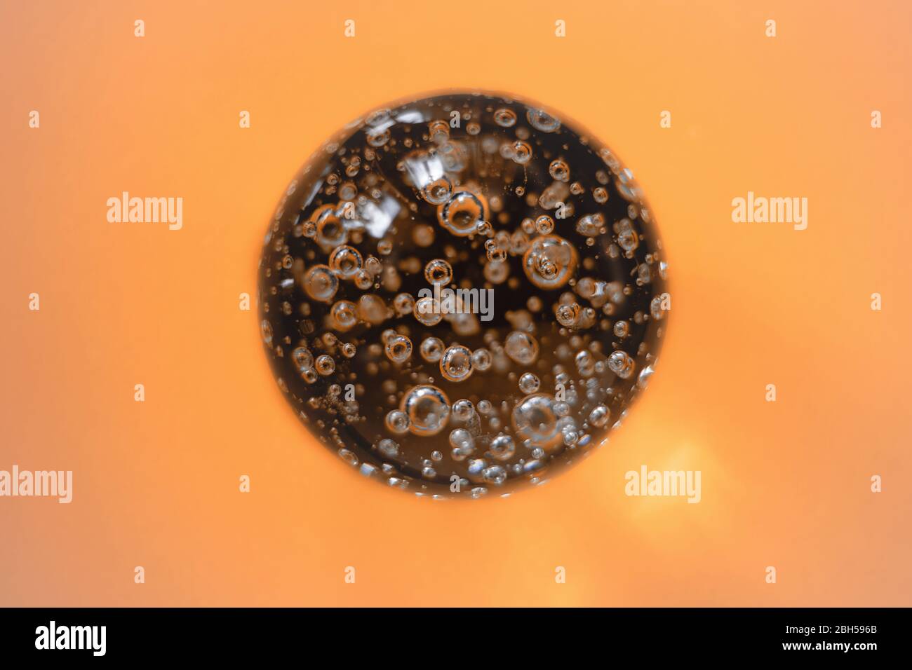 Glaskugel Kristall Kugel mit Blasen, isoliert auf orangefarbenem Hintergrund. Stockfoto