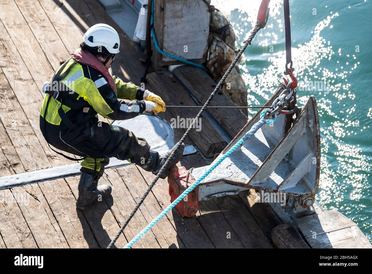 23. April 2020, Schleswig-Holstein, Helgoland: Ein Arbeiter bereitet das Seil für eine Tonne vor. Startschuss für ein großes maritimes Testfeld vor Helgoland: Wissenschaftler des Testzentrums für Maritime Technologien haben in der Nähe der Nordseeinsel mit Tonnen eine Fläche von drei Millionen Quadratmetern markiert. Es soll künftig Testeinrichtungen für die maritime Robotik bereitstellen. Hersteller und Wissenschaftler können dort verschiedene Szenarien testen. So können beispielsweise autonome Unterwasserfahrzeuge für Offshore-Windenergieanlagen unter realen Bedingungen im Meer getestet werden oder Drohnen, die über das fliegen Stockfoto