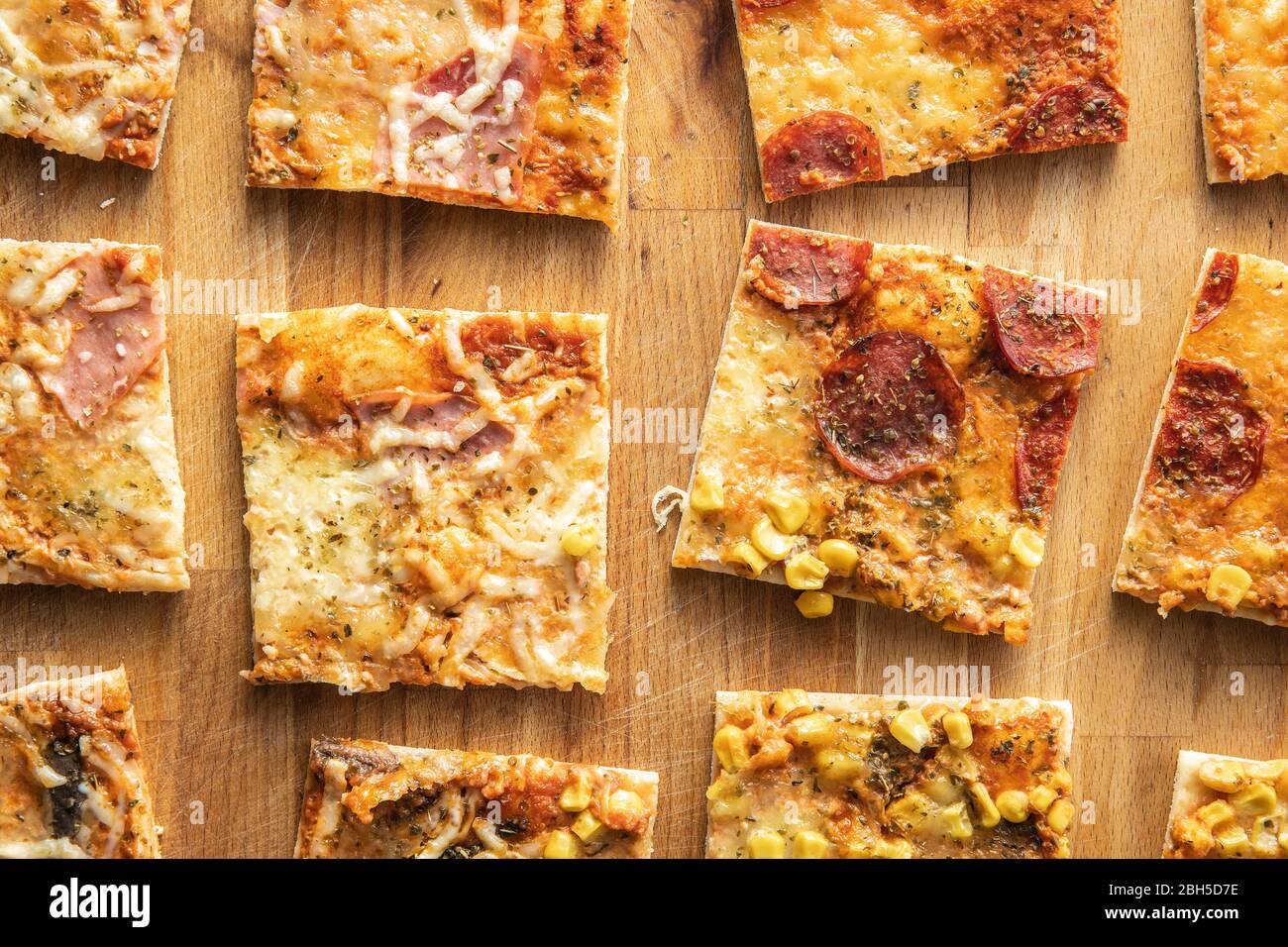 Stücke von hausgemachter italienischer Pizza auf Backpapier. Draufsicht. Stockfoto