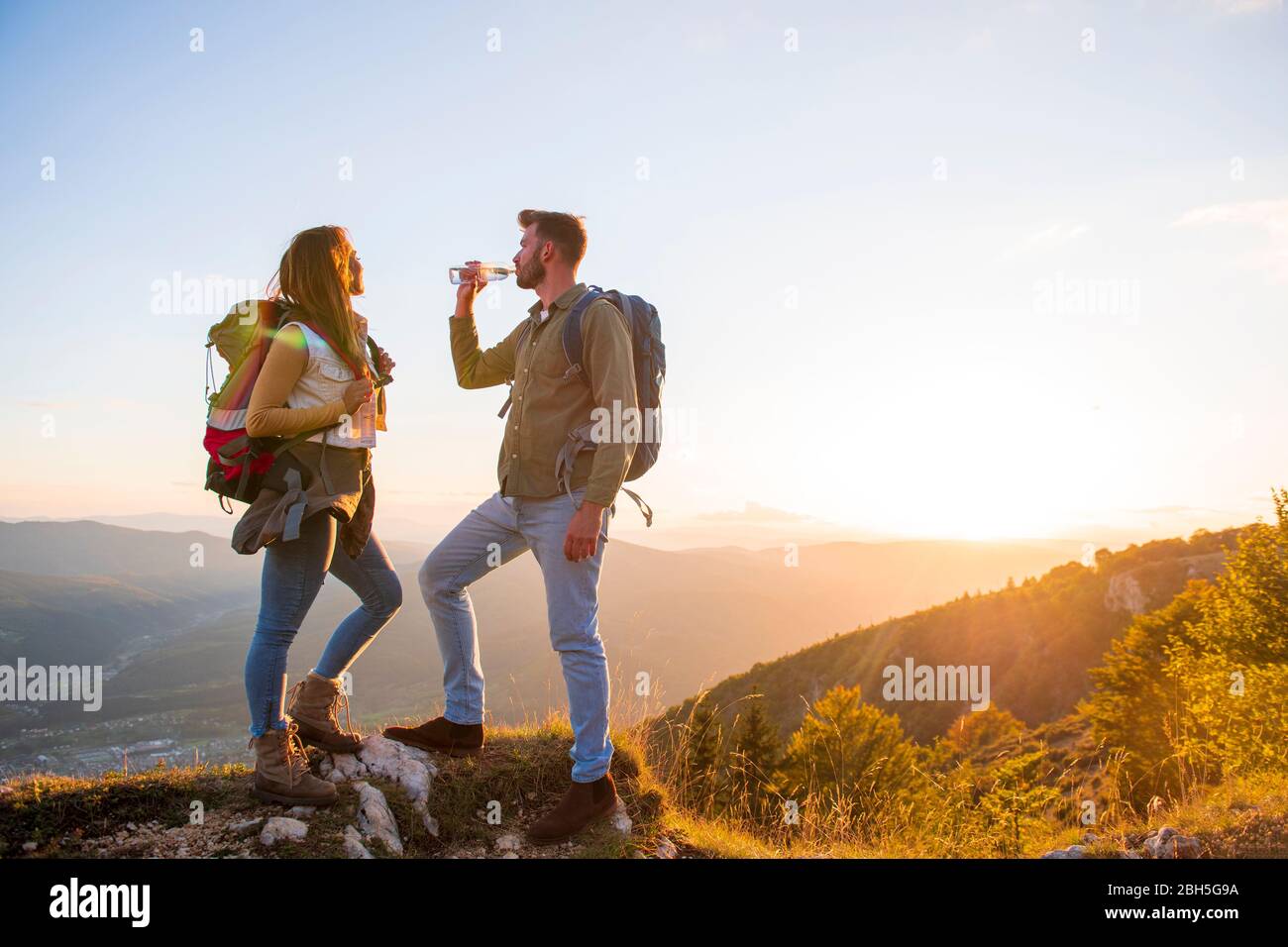 Junges Paar Wandern auf dem Gipfel des Berges Trinkwasser Stockfoto