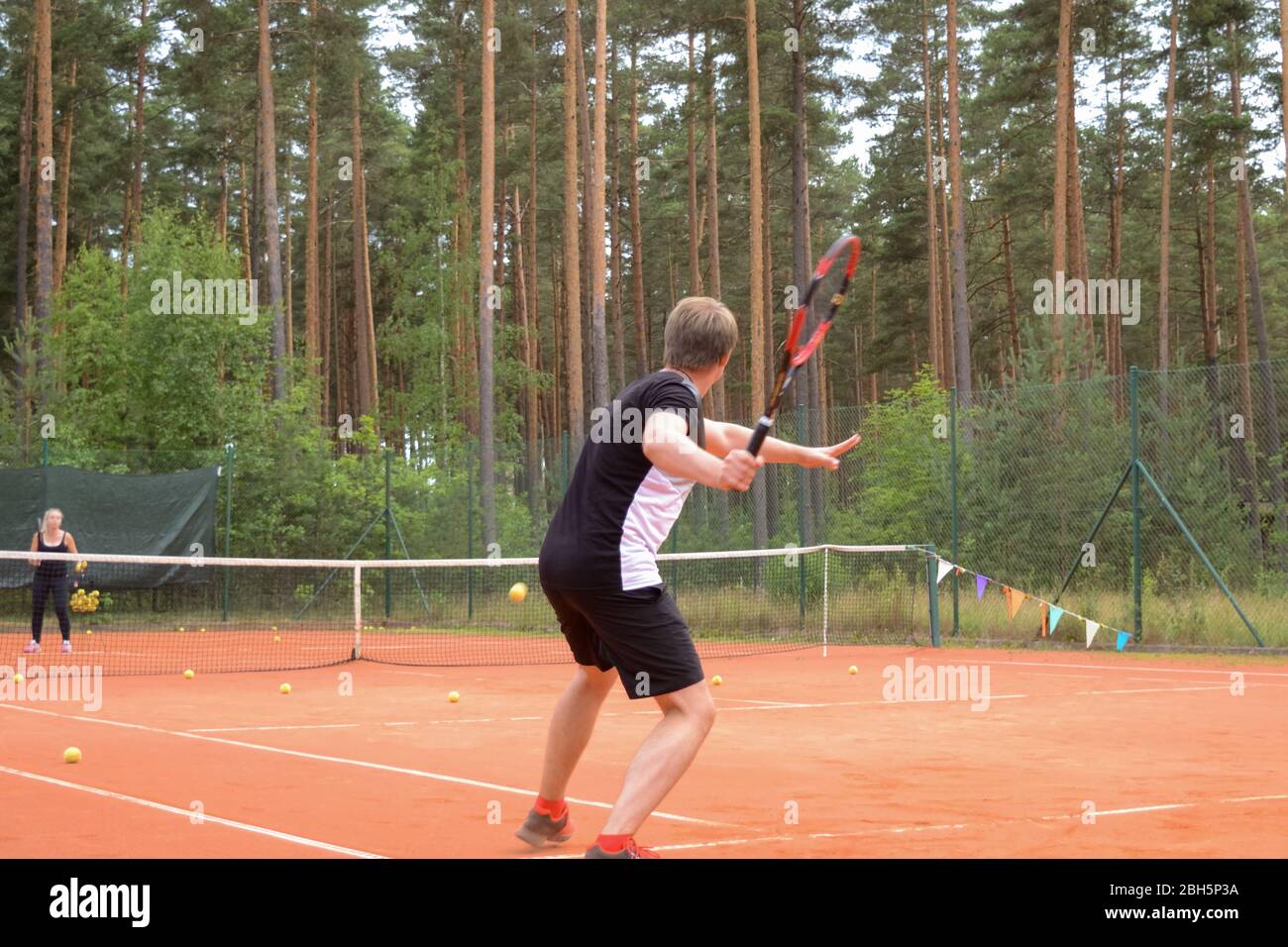 Rückansicht eines männlichen Tennisspielers mit einem Schläger, der auf einen Pass des Gegners wartet Stockfoto