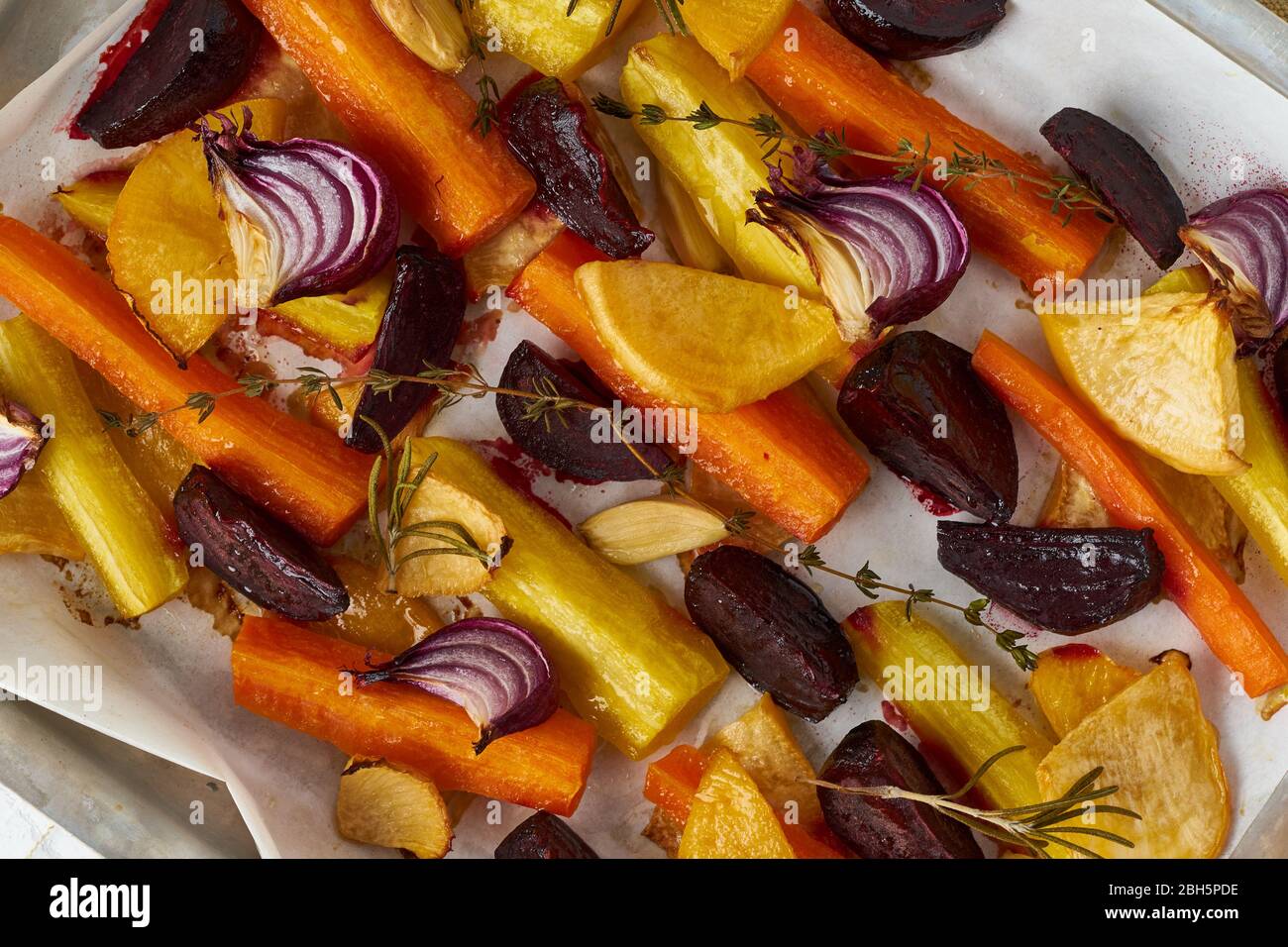 Buntes geröstetes Gemüse auf dem Tablett mit Pergament. Mix aus Karotten, Rüben und Rüben Stockfoto