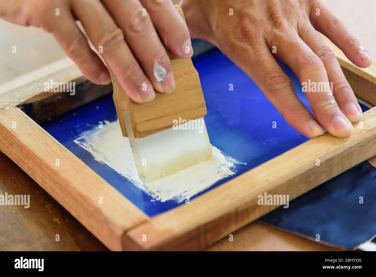 Seidenschirm weißes Text-Logo von Hand Stockfoto